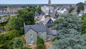 Een woonwijk met stenen huizen, een kerktoren en weelderige begroeiing.