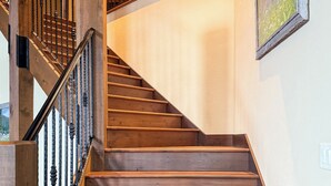 A wooden staircase with a black railing, leading to an upper floor. - Lodge with Incomparable Views & Direct Ski Access (Whitefish)
