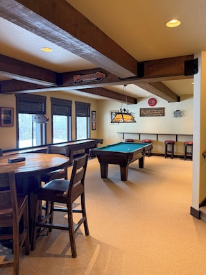 Une table de billard, des chaises, un coin bar et une enseigne indiquant « Service après-vente agréé Harley-Davidson ».