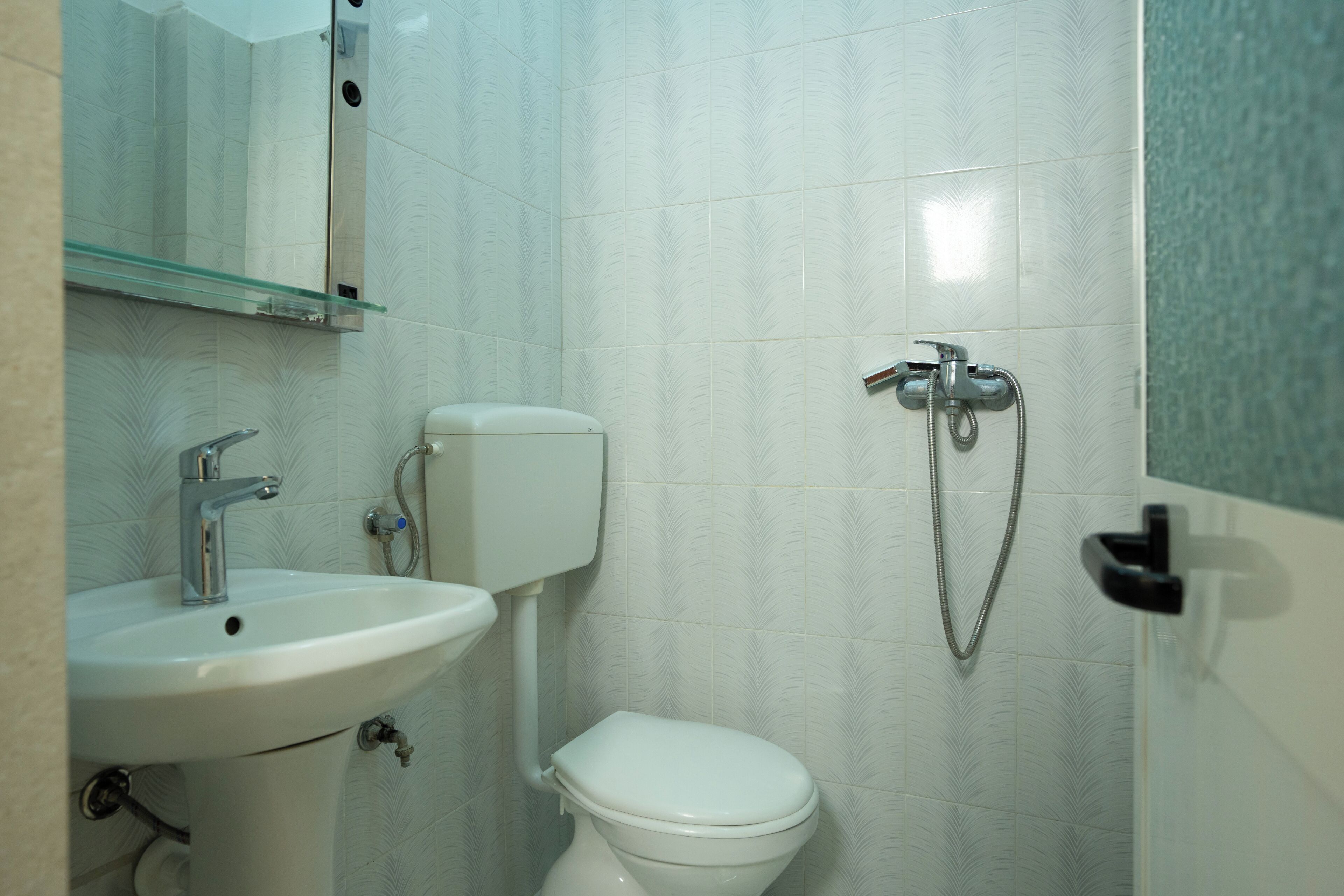 Un baño con lavamanos, inodoro y ducha blancos.
