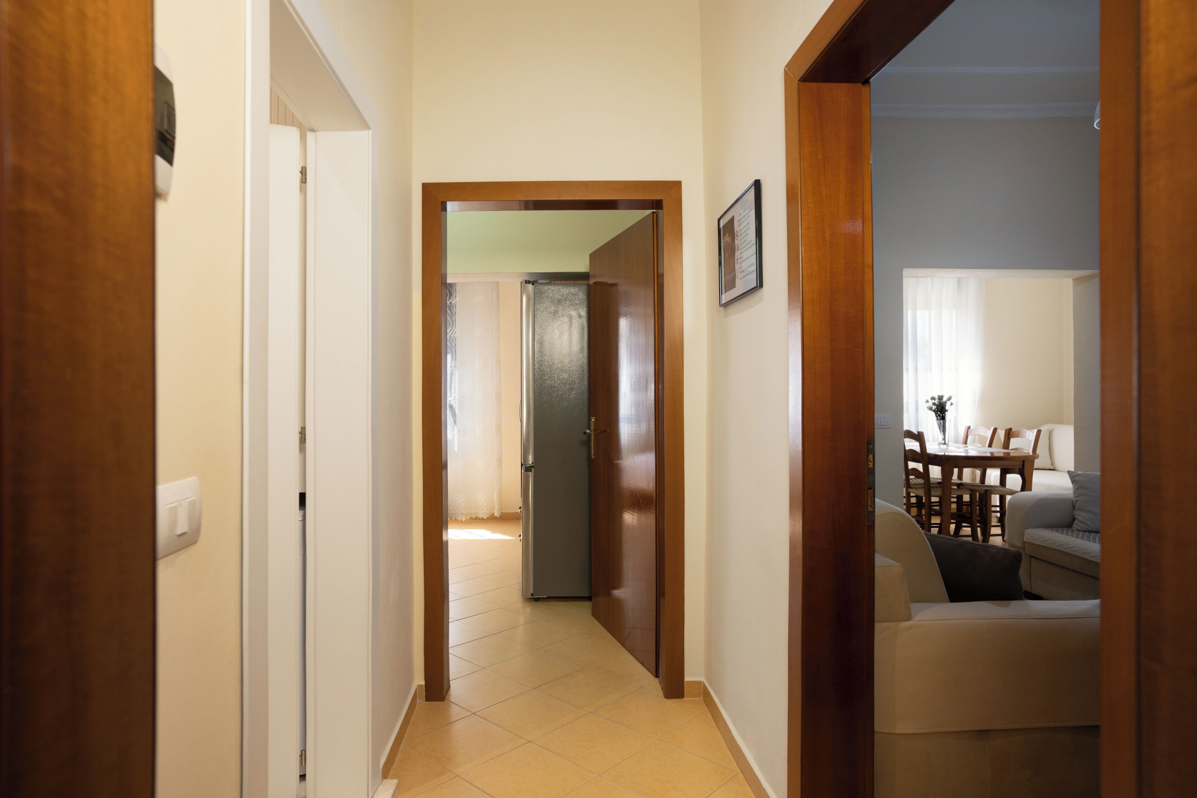A hallway leading to a dining area with a table and chairs.