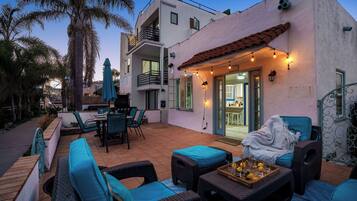 A patio with outdoor furniture, a grill, and a view of the interior.