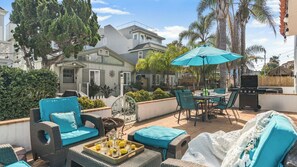 An outdoor patio with wicker furniture, a grill, and a view of neighboring houses. - Ormond Court Unit 1 by Avantstay 3 Blocks to Sand + Walk to Belmont Park Mission Beach (San Diego)