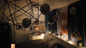 A bedroom with a bed, a desk with a lamp, a window with curtains, and wall decorations. - Artist’s Studio Steps from Sunset Plaza. Prime West Hollywood Location (West Hollywood)