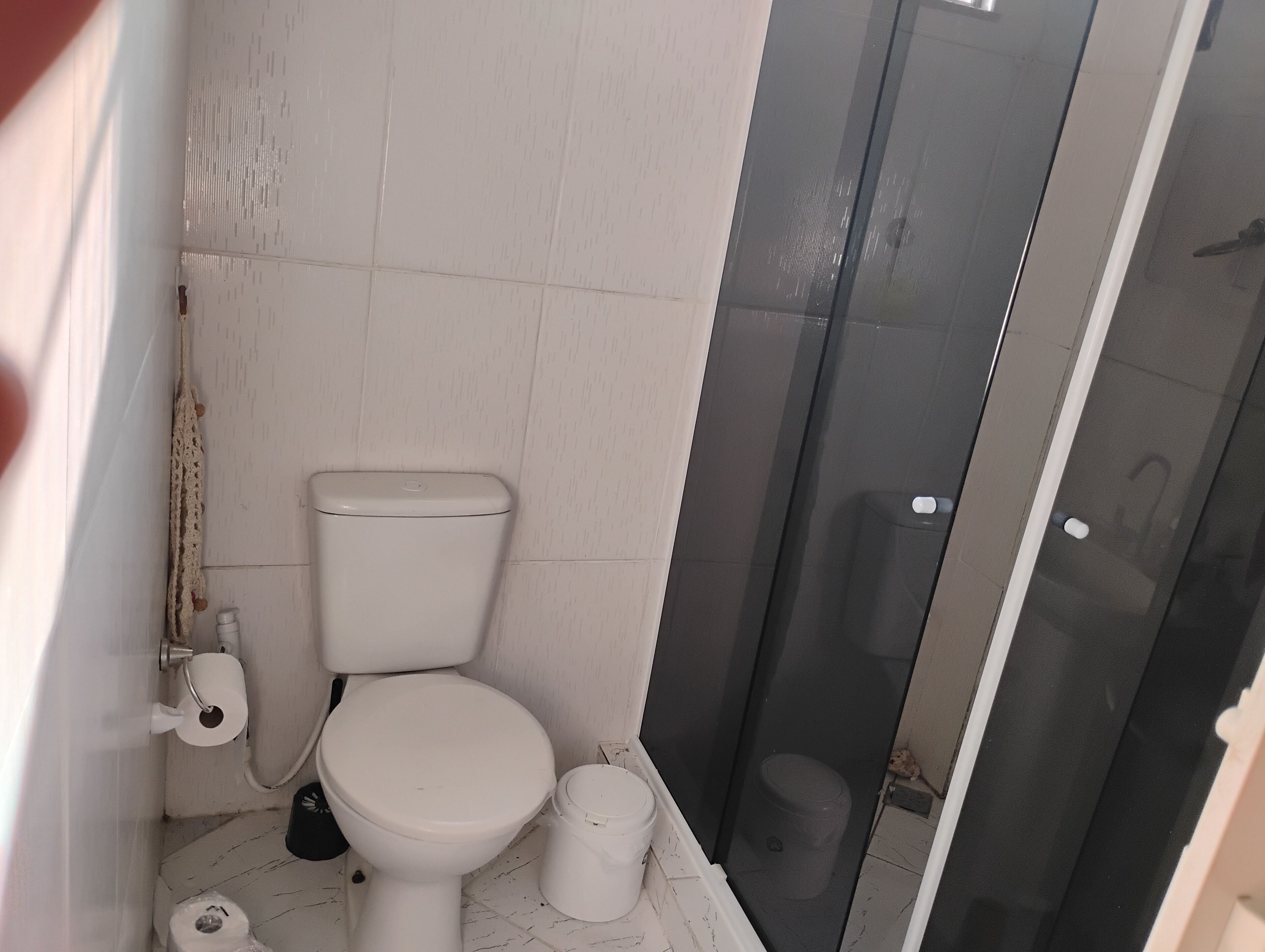 Chuveiro, toalhas de banho, sabonete, papel higiênico