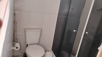 Chuveiro, toalhas de banho, sabonete, papel higiênico