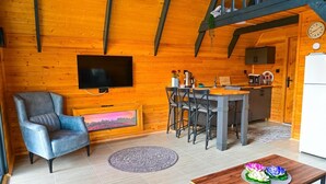 Ein gemütliches Blockhaus-Interieur mit Fernseher, Essbereich und Küche.