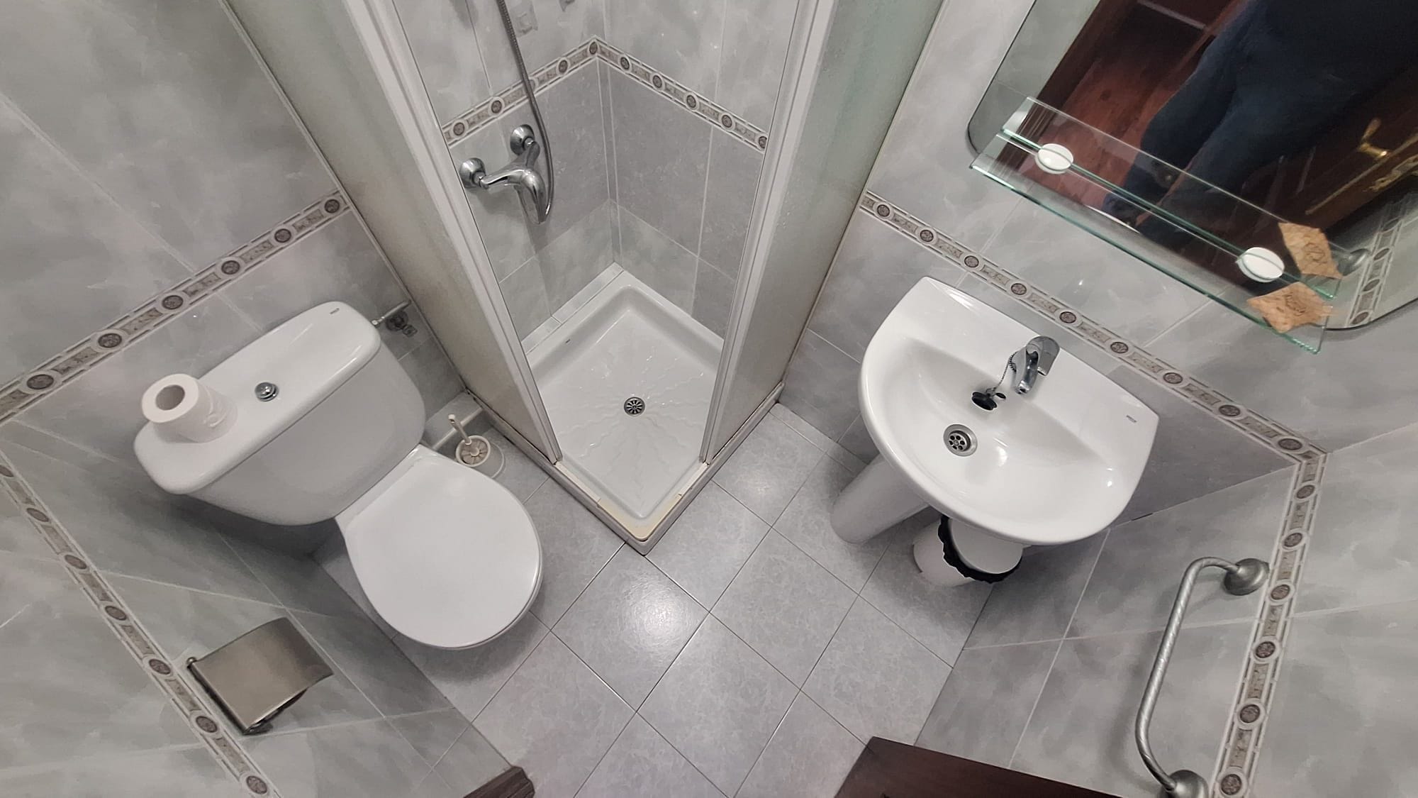 Een badkamer met toilet, bidet, douche en wastafel.