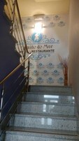 Una escalera conduce a un restaurante con un logo y el nombre 'Caminho do Mar Restaurante' en la pared.