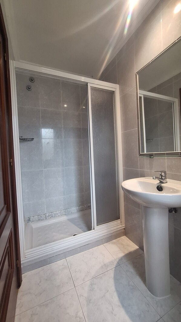 A bathroom with a shower enclosure, a sink, and a mirror. - My Rooms Hotel Camiño do Mar (Rois)