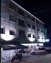 Un hotel de diseño moderno, con varias ventanas y un letrero de neón.