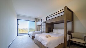 Un dormitorio moderno con literas, un amplio ventanal corredero y vistas al exterior.