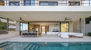 Ein moderner Außenbereich mit Pool, Essbereich und Lounge-Bereich.