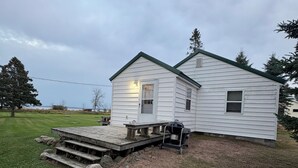A small, single-story house with a front porch and a deck.