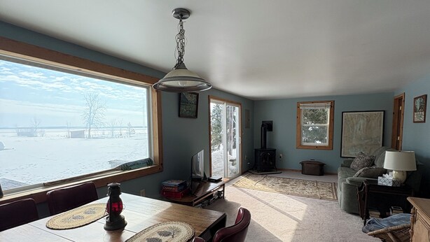 A dining area with a table, chairs, and a view of the outdoors.