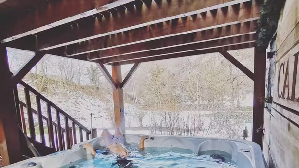 A hot tub under a wooden pergola with a view of a snowy landscape. - Mini house with full kitchen (Campan)