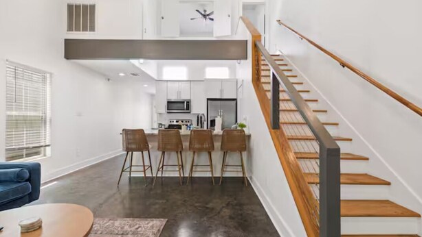 A modern interior with a kitchen, dining area, and a staircase. - Oaks Cottages Modern 2BR Retreat (Lafayette)