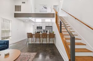 Een modern interieur met een keuken, een eetgedeelte en een trap.