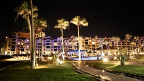 A hotel with multiple floors, a swimming pool, and palm trees. - Comfy & Updated 4th Floor Condo Princesa E-401 (Puerto Peñasco)