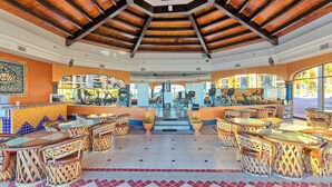 A hotel lobby with a central staircase, seating areas, and exercise equipment. - Comfy & Updated 4th Floor Condo Princesa E-401 (Puerto Peñasco)