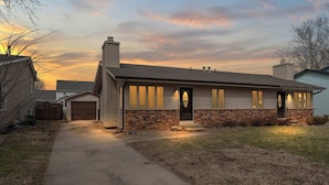A two-story house with a brick facade, a chimney, and a garage. - 3BR-2BA, Sleeps 8 | Close to I-35 (Ames)