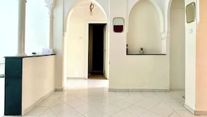 A spacious lobby with a reception desk, a large brown ottoman, and a ceiling fan. - 2-bedroom apartment for 6 in Gueliz near the train station (Marrakesh)