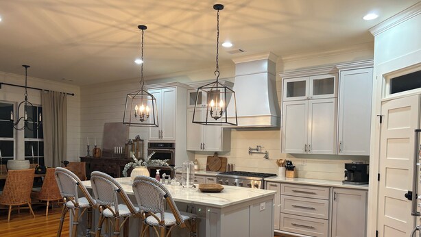 A kitchen with a central island, bar stools, white cabinetry, and a stove. - Masters rental -40 mins from tournament (Lincolnton)