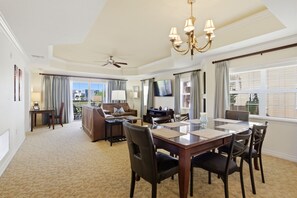 A hotel room with a dining area, a sofa, a TV, and a chandelier. - New! Sunset Luxe Retreat at Reunion (Kissimmee)