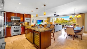 A modern kitchen with granite countertops, stainless steel appliances, and a large island. - Honua Kai 4 Free Rental Cars KBM Resorts Grand Suite 4 Units, 9 Bedrooms HK Ml-2663 (Kaanapali)