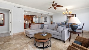 A living room with a sectional sofa, a coffee table, a dining area with chairs, a chandelier, and a ceiling fan. - Honua Kai Close To Beach 2 Free Rental Cars KBM Resorts 2 Units, 5 Bedrooms HK Ml-2651 (Kaanapali)