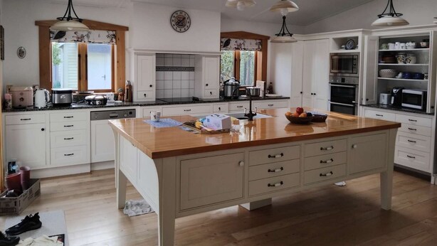 A spacious kitchen with a central island, skylights, and white cabinetry. - LLU HOMES FOR EXPLORERS (Westport)