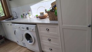 A kitchen with a washing machine, a sink, and a window. - LLU HOMES FOR EXPLORERS (Westport)