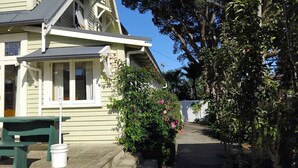 A house with a porch, a green bench, and a pathway leading to the house. - LLU HOMES FOR EXPLORERS (Westport)