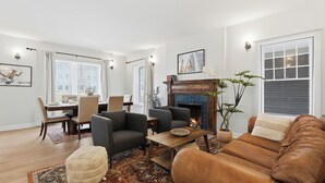 Una sala de estar con chimenea, zona de estar, mesa de comedor y elementos decorativos.