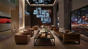 Eine moderne Lounge mit Sofas, einem Couchtisch und einem großen Fenster mit Blick auf die Stadt.