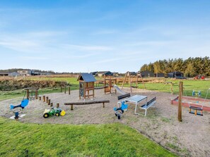 A playground with various play equipment including swings, slides, and climbing structures. - 4 Star Holiday Home in Lokken (Lokken)