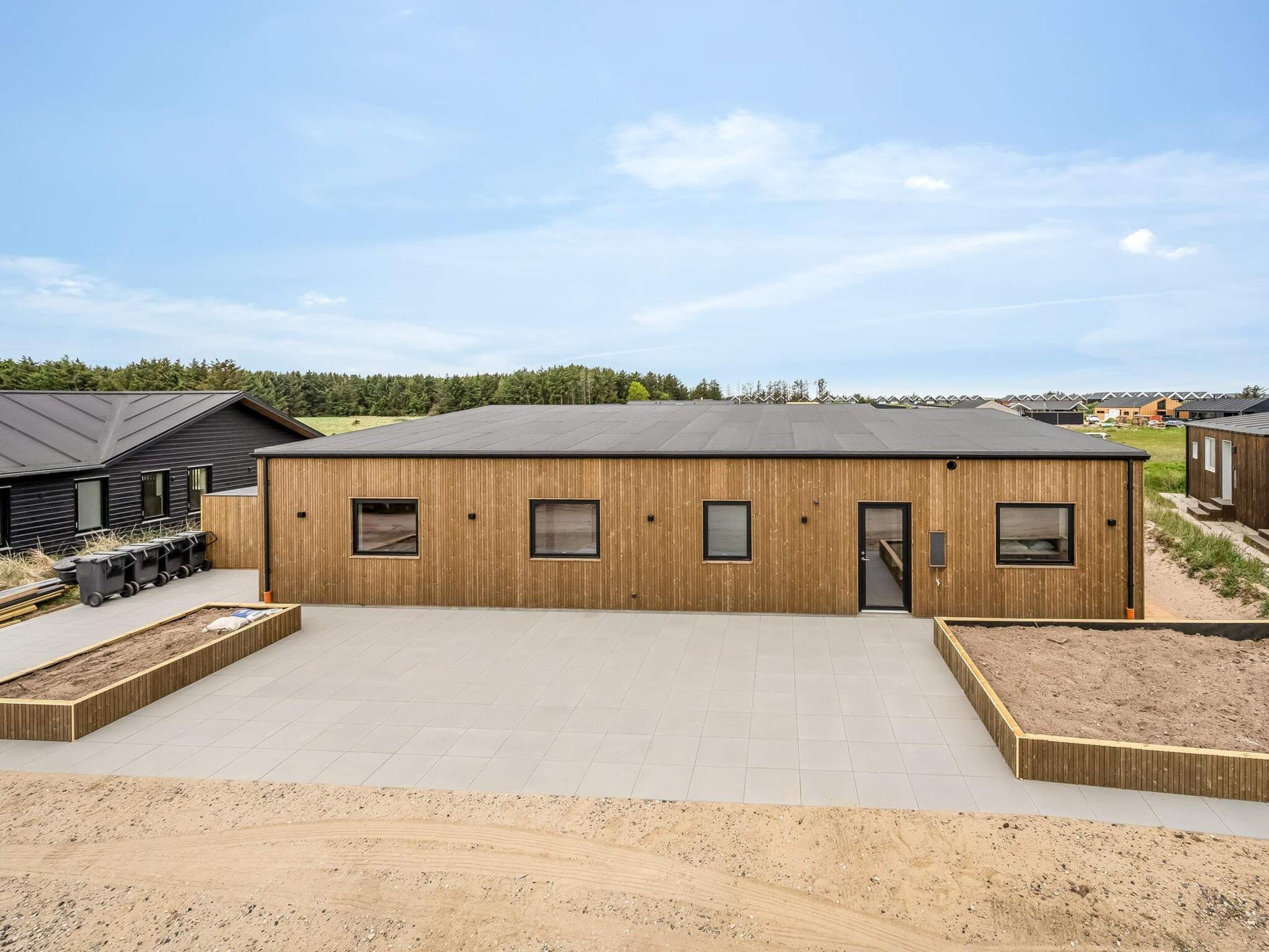 A modern building with a flat roof, rectangular windows, and a wooden facade.