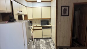 A compact kitchen with a refrigerator, microwave, and sink.