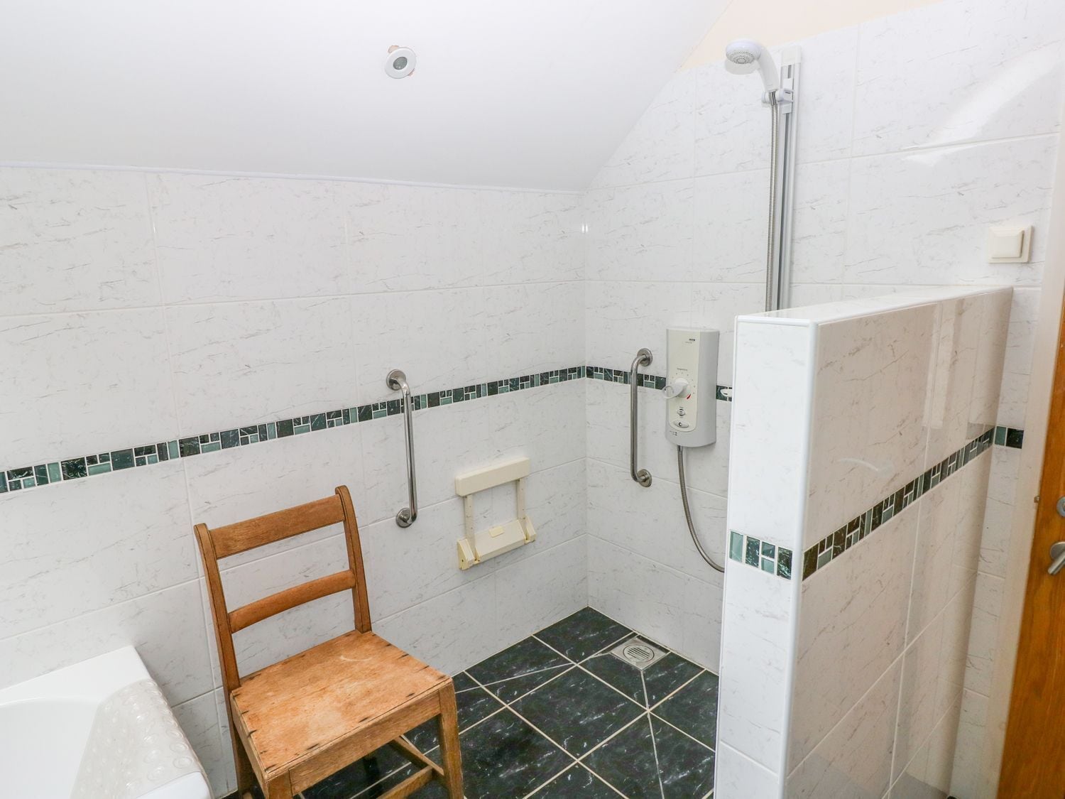 Un área de ducha con múltiples cabezales de ducha de mano.