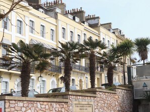 A row of yellow buildings with stone walls and palm trees in front. - Boats Galore - Torquay Marina&nbsp; (Torquay)