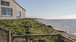 Un edificio con un letrero que dice 'Beachcroft Bakehouse' con vista a la costa.