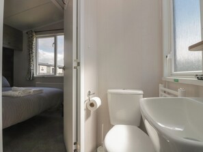 A bedroom with a bed, a toilet, and a bathtub. - The Plover (St Bees)
