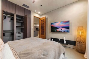 A bedroom with a bed, a wardrobe, a television mounted on the wall, and a lamp. - Paradise South Lake Tahoe 2 Bedroom  (Unit D) (South Lake Tahoe)