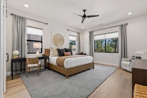 A bedroom with a bed, desk, chair, and a large window. - NEW! | Single-Level | Hot Tub | AC | Int Design (Flagstaff)