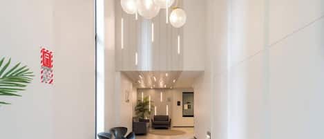 A modern interior with a reception area, seating, and a plant.