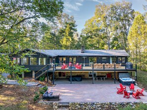 Une cabane à deux étages dotée d’une terrasse, de meubles de jardin et d’un bain à remous.