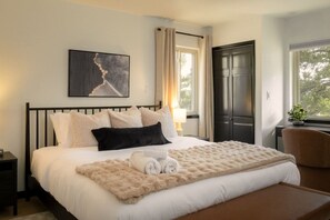 A hotel room with a bed, a painting, a window, and a door. - Red Rocks Gather - Hot tub, sauna, cinema & views (Morrison)
