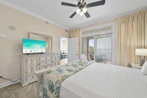 Ein Hotelzimmer mit einem Bett, einem Fernseher, einem Deckenventilator, einem großen Fenster und Blick ins Freie.