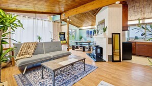 Un salon chaleureux avec un canapé, une table basse et un coin repas comprenant une table et des chaises.