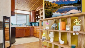 Una cocina moderna con armarios de madera, horno empotrado y un amplio ventanal.